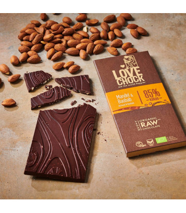 Foto creativa de tableta de chocolate negro ecológico al 85% con almendra y baobab